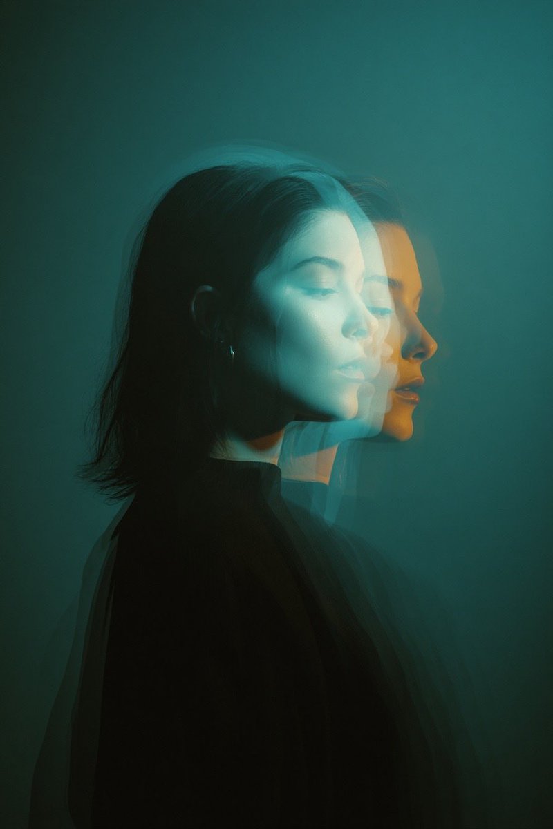 Cinematic double exposure portrait of a woman in side profile, two overlapping faces slightly offse…