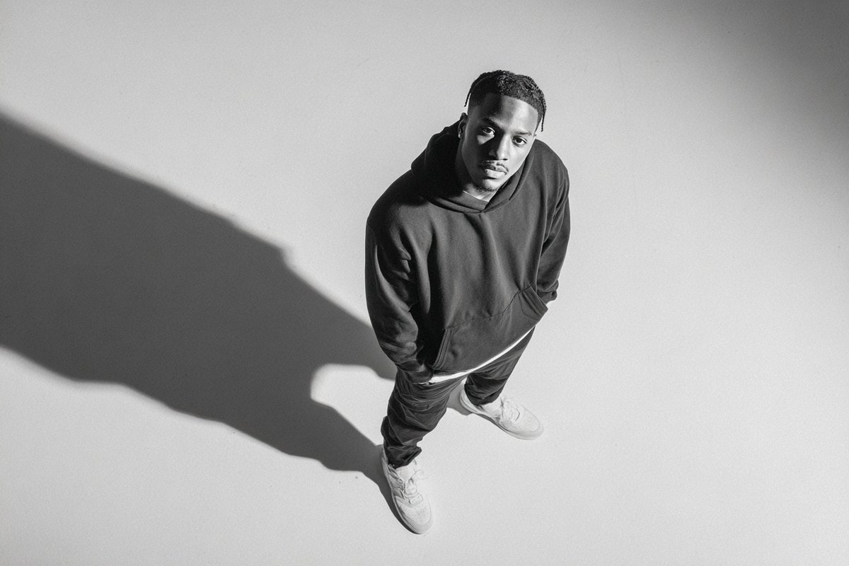 A [subject] photographed from a 35-degree overhead angle, standing alone in an off-white studio voi…
