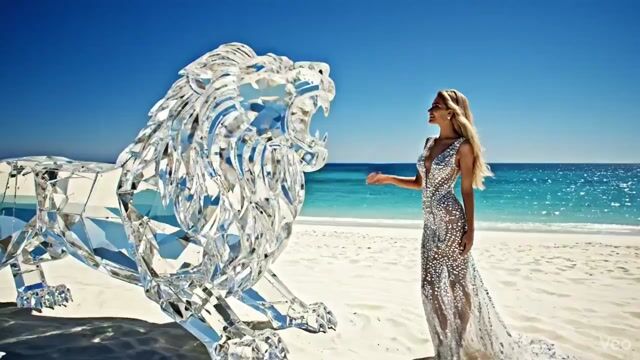 Huge diamond-like lion roaring on a white beach with an elegant woman